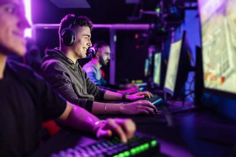 Happy gamer playing favorite game at gaming room.