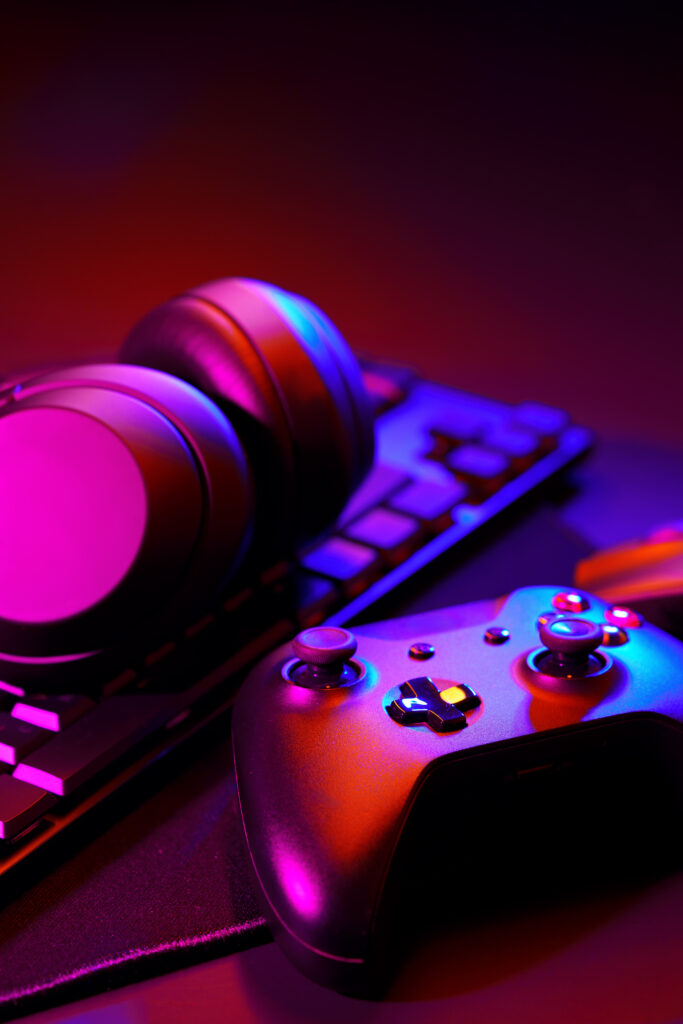 Headphones, joystick and computer keyboard on black table