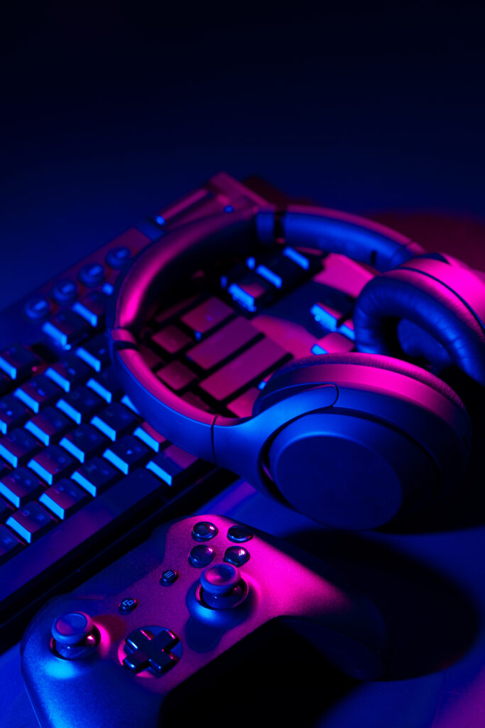 Headphones, joystick and computer keyboard on black table